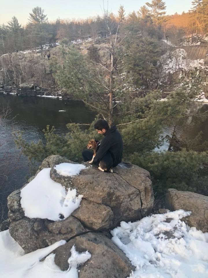 Ramiro and Andy sitting together near a rocky overlook